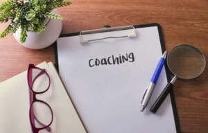 Clipboard on desk with “coaching” written on the paper