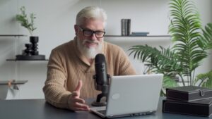 Oudere man lachend en spreekt in een podcast microfoon